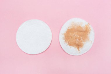 Makyaj için iki pamuk pedi. Pembe arka planda kirli ve temiz. Makyajı kaldırdıktan sonra kirli ve temiz bir kozmetik ped. Hijyen kavramı