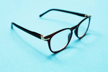 Mavi arka planda görüş için gözlük. Kötü görüş konsepti. Gözlerine dikkat et..