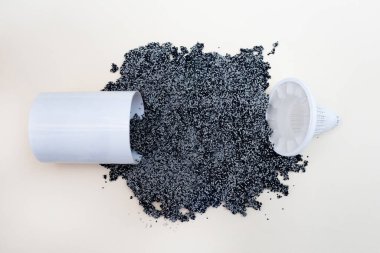 Su arıtma için filtreyi kes. Değiştirme filtresi sürahi kartuşu. Karbon ve beyaz granüllerden yapılmış filtre malzemesi. Bir sürü kömür topu saçılmış. Düz yatıyordu