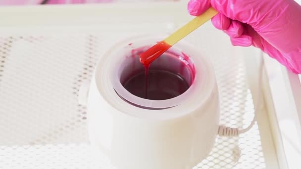 Rött vax smälter i elektriska vax värmare för hårborttagning i spa salong. — Stockvideo