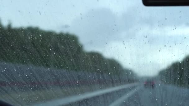 Dešťové kapky stékají po čelním skle, protože jsou proti dešti. Leštidlo na auta. — Stock video