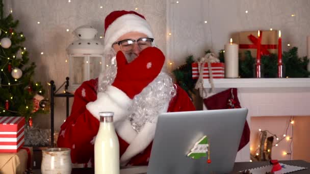 サンタクロースは彼のクリスマスワークショップであくびをし、クリスマスの乳製品を飲むミルク — ストック動画
