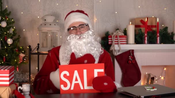 Vrolijk kerstfeest te koop korting. Kerstman met rood verkoopbord. — Stockvideo