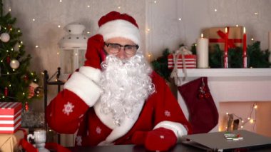 Noel Baba cep telefonuyla konuşuyor ve gülümsüyor. Yavaş çekim.