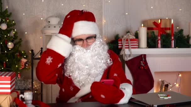 Santa Claus čte zprávy na sociálních sítích po telefonu. Santovi se to nelíbí.. — Stock video