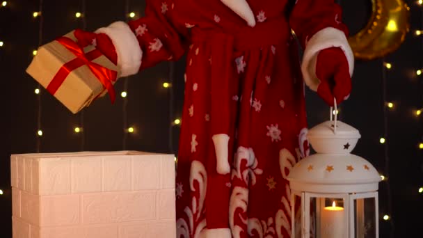 Père Noël met cadeau de Noël dans la cheminée de la maison, dit au revoir et s'en va. — Video