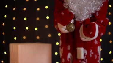 Noel Baba kaplan renkli Noel topunu evin bacasının yanında tutuyor. Sihirli gece.