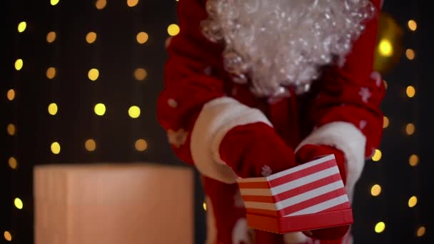 Santa Claus pone la llave del apartamento en la caja de regalo de Navidad y la cierra. — Vídeos de Stock