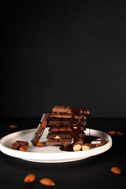 Eritilmiş sıvı çikolata, içinde badem olan çikolata parçaları olan bir tabağa dökülür. Dikey yönelim