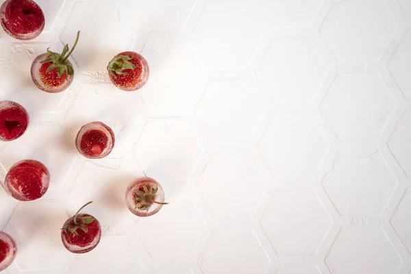 Frambuesa y fresa congeladas en cubitos de hielo cubiertos de escarcha. Comida casera. Vista superior. Copiar espacio. —  Fotos de Stock