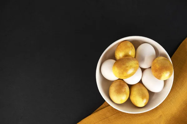 stock image Yellow Easter eggs in a bowl on a dark background. Natural duing Easter eggs with turmeric powder in yellow color.