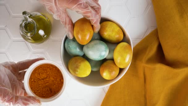 Natural coloring Easter eggs with turmeric. Olive oil gives shine to eggs. — Stock Video