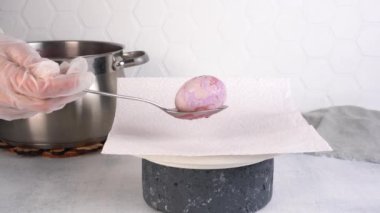 Paskalya yumurtalarını çiçek desenli çayla boyamak. Yumurta mor olur..