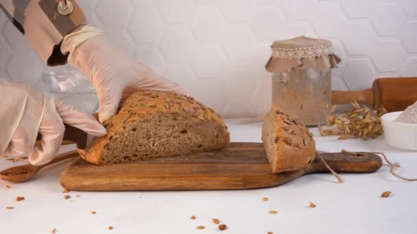 Ο σεφ κόβει σπιτικό ψωμί σε φέτες. Ζυθοζύμη στο φόντο. — Αρχείο Βίντεο