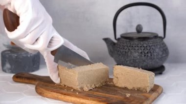 Kesme tahtasındaki Türk ve Arap tatlıları susam halkası. Ulusal yemek. Türk lokumu. Tahini halva parçaları. Arka planda çaydanlık.