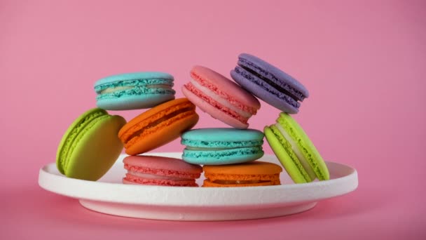 Le mani delle donne prendono deliziosi macaron francesi colorati dal piatto. 8 marzo. — Video Stock
