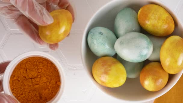 Natural coloring Easter eggs with turmeric. Olive oil gives shine to eggs. — Stock Video