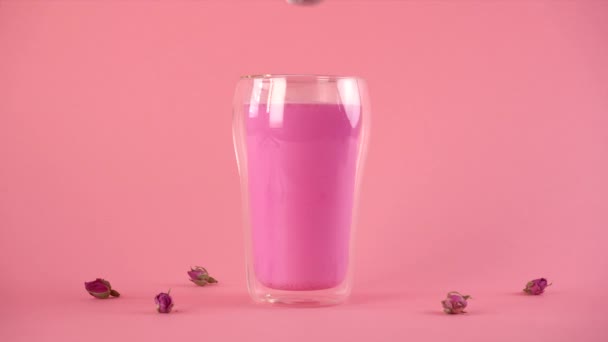 Рожеве трояндове молоко. Додавання піни теплим молоком до склянки місячного молока. Здоровий напій . — стокове відео