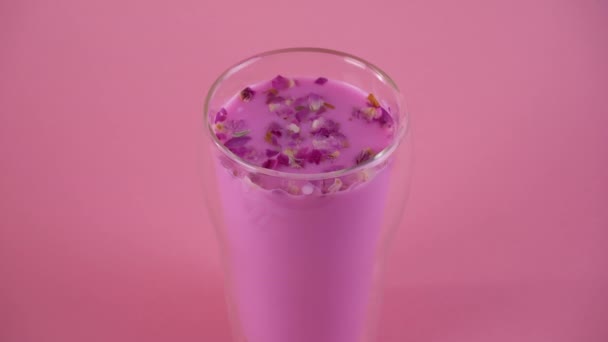 Rosa de leche de rosa con pétalos de rosa. Un vaso de leche de luna. Bebida saludable. Zoom-in. — Vídeos de Stock