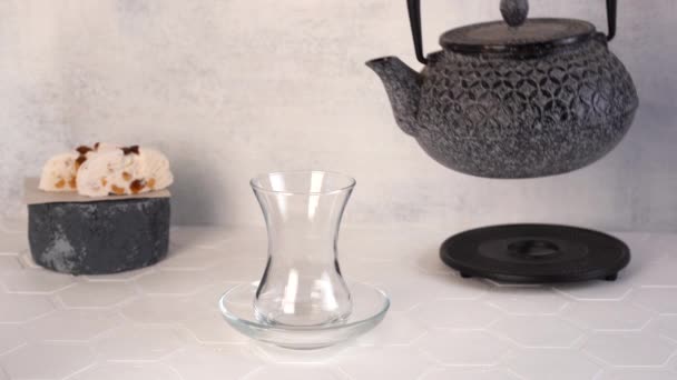 Tea is poured from a teapot into a traditional Turkish glass armudu. — Stock Video