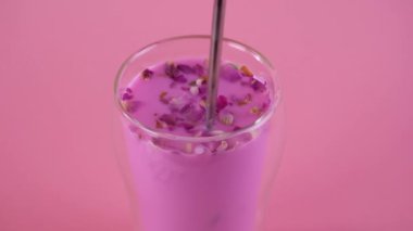 Pembe gül sütüyle kaşığı karıştırıyorum. Bir bardak ay sütü. Yavaş çekim.