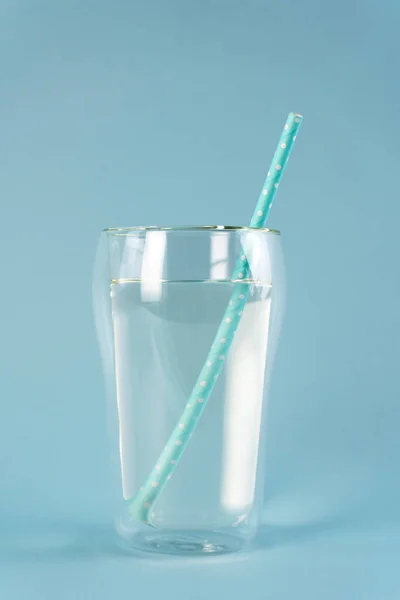 生の純水のガラスに青いストローを飲みます。垂直方向. — ストック写真