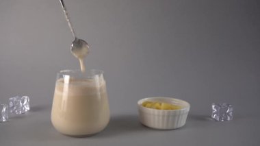 Geleneksel Hint mangosu lassi içkisi. İçkiyi kaşıkla karıştırmak. Yavaş çekim.