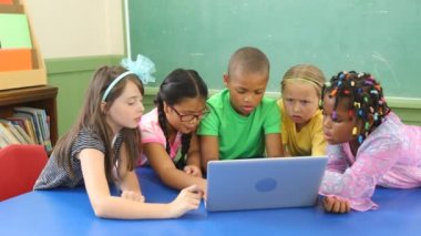 Dizüstü bilgisayarda oynayan bir grup çocuk