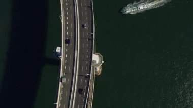 Tokyo, Japonya 2018 dolaylarında. Gökkuşağı Köprüsü 'nün yukarıdan görünüşü ve altından geçen fütürist tekne. Kırmızı kamerayla helikopterden çekilmiş..