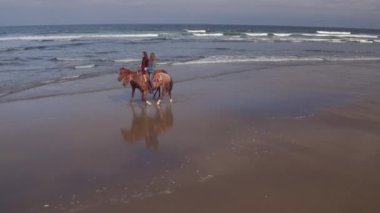 Kumsalda ata binen kadınların hava manzarası.