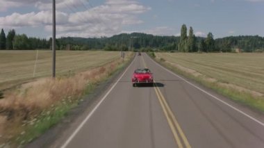 Country Road 'da klasik üstü açık araba kullanan bir adamın görüntüsü. Ticari kullanım için tamamen serbest.