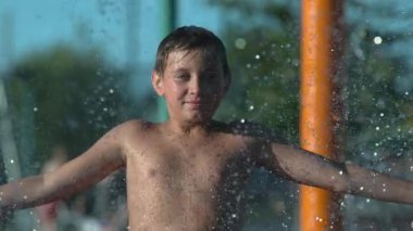 Çocuk parkta fıskiyede oynuyor. Çok yavaş çekimde.