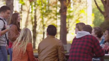 Kampüsteki bir grup üniversite öğrencisi açık havada buluşuyor.