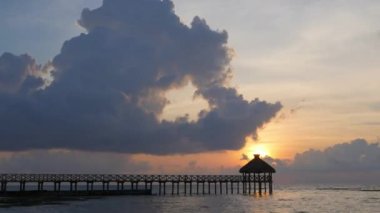 Okyanus üzerinde gün doğumu ve tropikal tatil beldesinde rıhtım