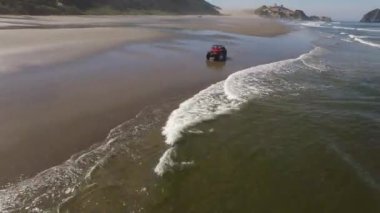 Sahilde giden 4x4 off road aracının hava görüntüsü.