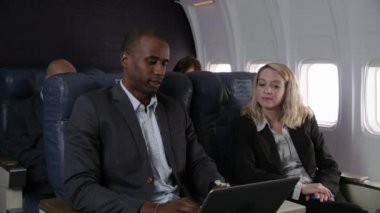 Uçak uçuşunda çalışan iş adamları.