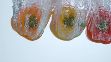 Çan biberleri yavaş çekimde suya dökülüyor.