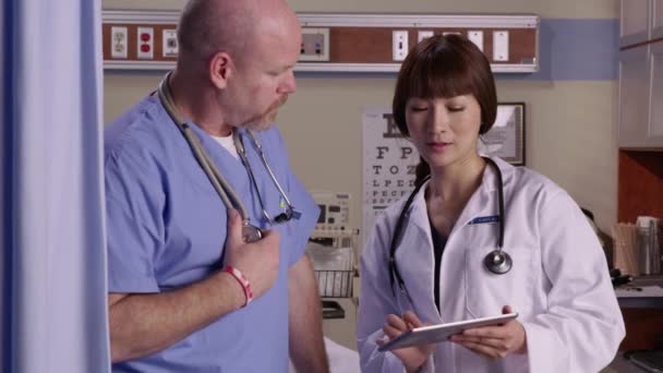 Lääkäri Mies Sairaanhoitaja Tarkastella Digitaalinen Tabletti Yhdessä — kuvapankkivideo