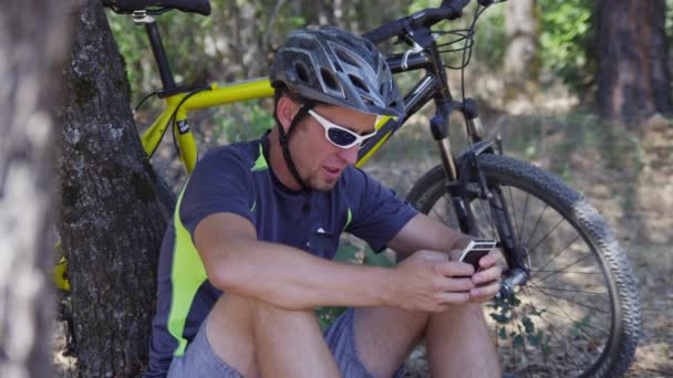 Hombre Con Bicicleta Montaña Sienta Tomando Descanso Comprobando Teléfono Celular — Vídeo de stock