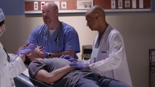 救急室の医師が頭部外傷のある男性を調べる — ストック動画