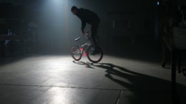 Bmx binici karanlık depoda hile yapıyor.