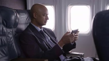 Uçakta dijital tablet kullanan bir işadamı