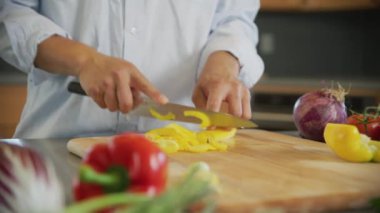 Sarı dolmalık biber kesen adamı yakından çek.