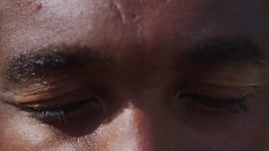 Afro-Amerikan erkek gözleri kameraya bakıyor.