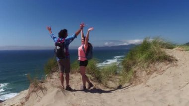 Kum tepelerinde yürüyüş yapan çiftler mola verip kutlama yaparlar.