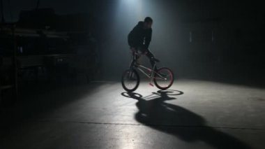 Bmx binici karanlık depoda hile yapıyor.