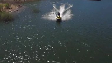 Gölde su aracına binen bir adamın insansız hava aracı görüntüsü.