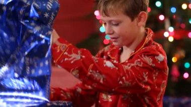 Çocuk Noel hediyesini yırtıyor.