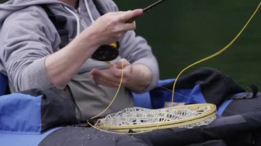 İnsan sineklerle balık tutarken yakın çekim.