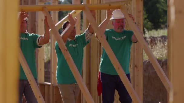 建設プロジェクトの壁を高めるために一緒に働くボランティア — ストック動画